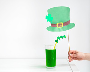 St. Patrick's Day holiday concept. Glass of green drink with with a tubule decorated with clover...