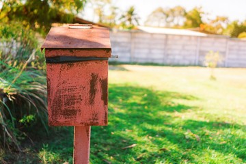 Red metal bin in the garden.