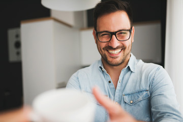 Handsome man having cup of coffee at home in the morning
