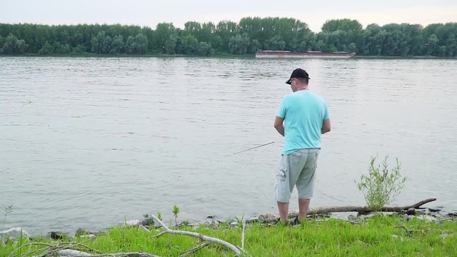 Angler is fishing on a river with a lure