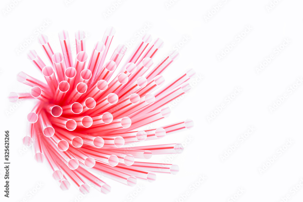 Wall mural Plastic straws with red and white stripes in a bunch isolated on a white background.  Plastic waste concept