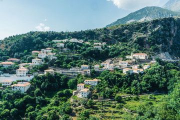 Fototapeta na wymiar The stunning mountain town of Dhermi, stuck in the middle of Albanian alps and your houses with dozens of windows, Albania