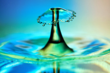 Water drop splash with a hat in color light close-up