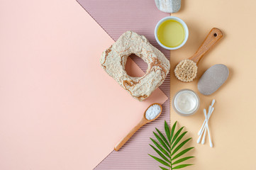 Accessories, olive oil and body care cosmetics on a light pastel background.