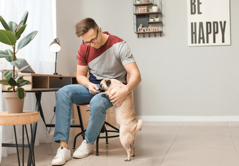 Handsome man with cute pug dog at home