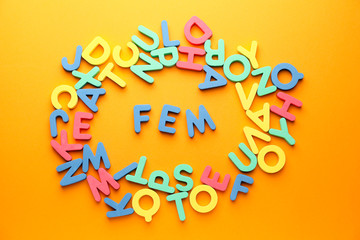 Many letters with word FEM on color background. Concept of feminism