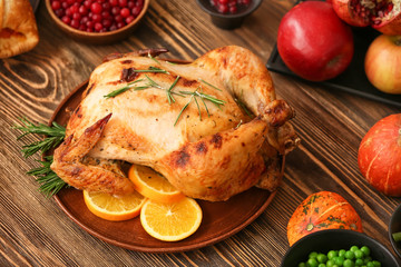 Tasty baked turkey for Thanksgiving day on wooden table