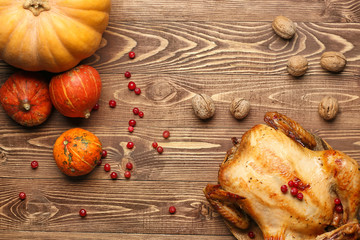 Tasty baked turkey for Thanksgiving day with harvest on wooden table