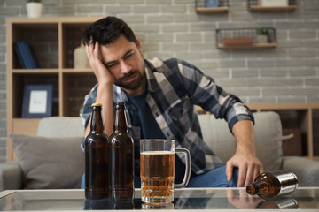 Man drinking beer at home. Concept of alcoholism