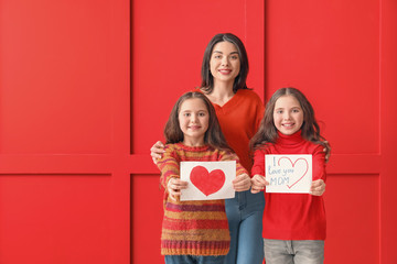 Little girls greeting their mom on color background. Mother's Day celebration