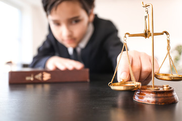 Little lawyer with scales of justice and book in office