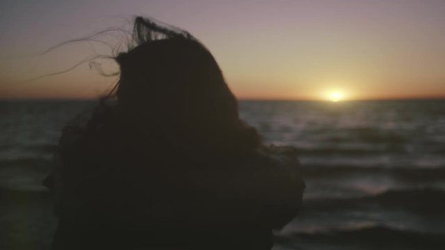 Girl on the shore of the cold North Sea. The wind blows her hair. The video was shot with a 12-bit movie camera.