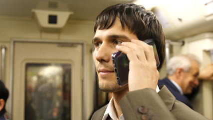 Businessman talking mobile phone in Subway