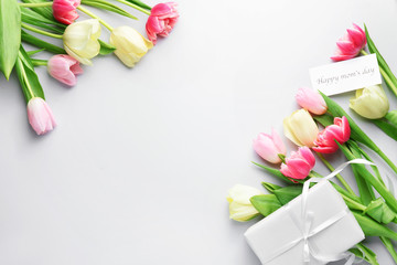 Beautiful flowers and gift for Mother's Day on white background