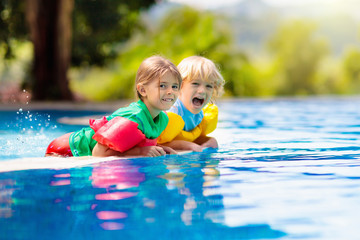Kids in swimming pool. Life jacket for child.