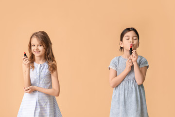 Cute little makeup artists on color background