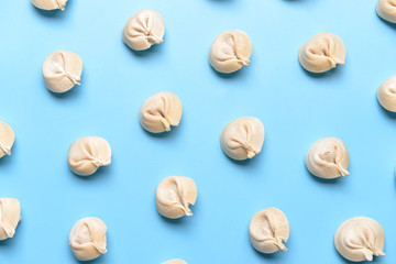 Raw fresh dumplings on color background