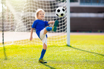Kids play football. Child at soccer field.