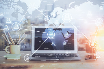 Computer on desktop with social network hologram. Multi exposure. Concept of international people connections.