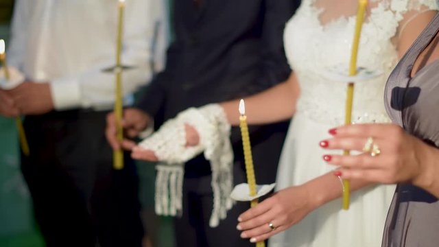 Hands of bride and groom in lace towel at church