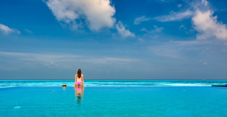 Woman in infinity swimming pool at Maldives