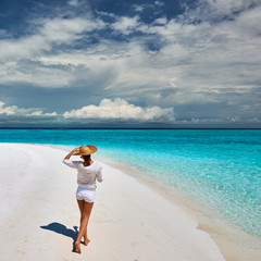 Woman with sun hat on tropical beach