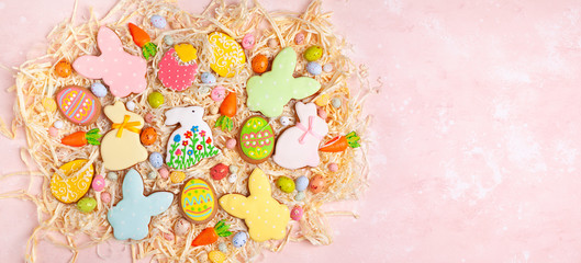 Fototapeta na wymiar Colorful Easter homemade gingerbread cookies in shape of eggs and bunny and candy. Easter baking concept.