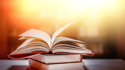 Stack of books in the library and blur bookshelf background