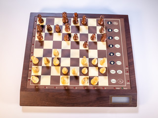  Top down view of chess pieces on an electronic chessboard on a white background