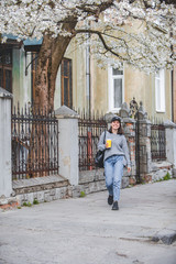 Fototapeta na wymiar young stylish woman walking by street with coffee cup
