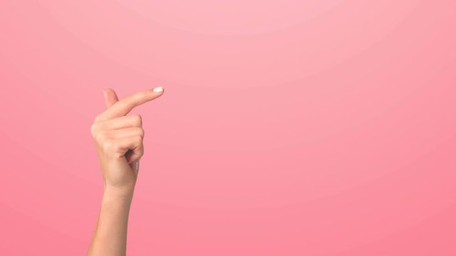Close-up of a woman's hand pointing to the right side. The girl enters her hand into the frame and points to the right with her index finger