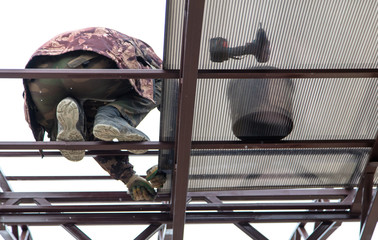 A worker mounts a metal canopy