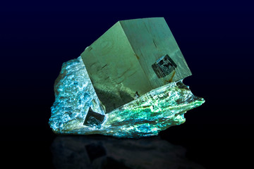 A close up of iron pyrite mineral isolated on dark/white background. 