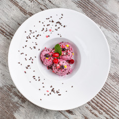 Fruit dessert decorated with mint, chocolate and berries in a white plate. Restaurant serving. Top view