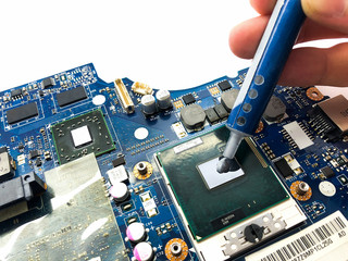 Thermal grease and motherboard isolated on white background. Replacing thermal grease on a laptop.