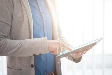 Close up of hand using tablet over window