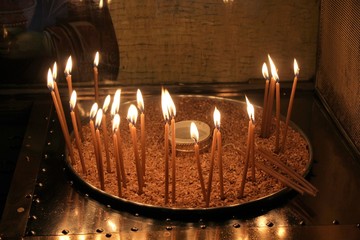 Lighting candles inside a Greek orthodox church.
