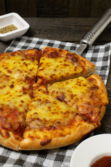 Pizza with Mozzarella cheese,Cheddar cheese on wooden background.