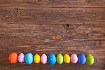 Line of easter eggs on wooden background
