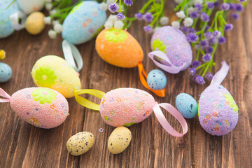 Fototapeta na wymiar Easter eggs and spring flower on rustic wooden background.