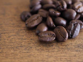 Coffee beans on brwon wooden background with copy space.