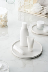 Fototapeta na wymiar Skincare products in white bottles on marble table