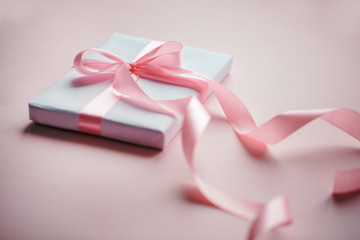 Decorative white gift box with pink bow and long beautiful ribbon.