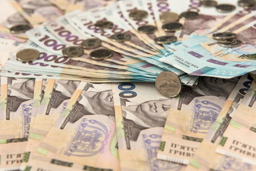 500 and 1000 bill ukraine money as background. gold coin lying on pile of grivna