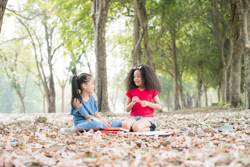 happy multi-ethnic children smiling playing in park..group of happy children playing outdoors. kid having fun in spring park. the kid reading a book on the holiday and picnic in the public park..