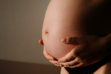 Femme enceinte tenant son ventre avec ses mains