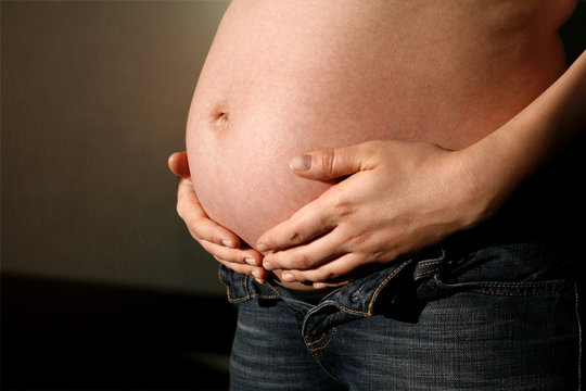 Femme enceinte qui tient son ventre avec ses deux mains