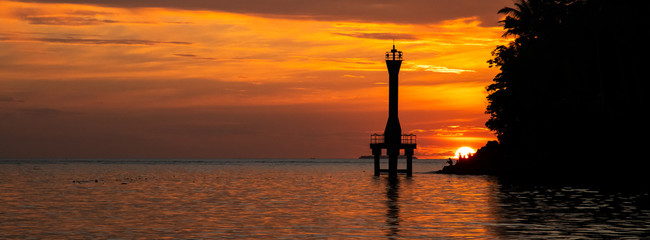 Obraz premium Sihouette of light house at the sea in sunset