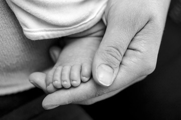 Main d'une mère qui tient le pied de son bébé
