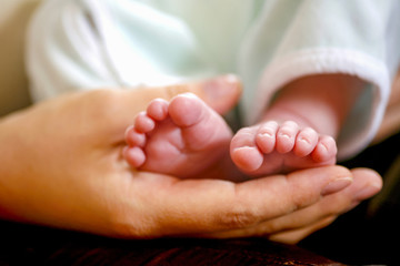 Pieds de bébé dans la main de sa mère